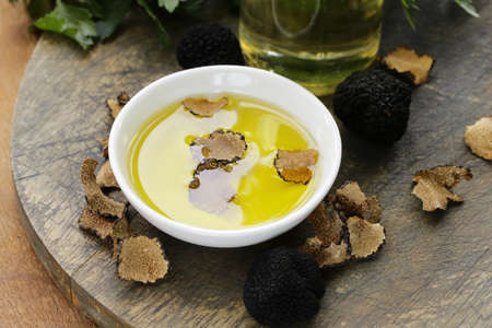 Olive oil flavored with black truffle on a wooden tableの写真素材