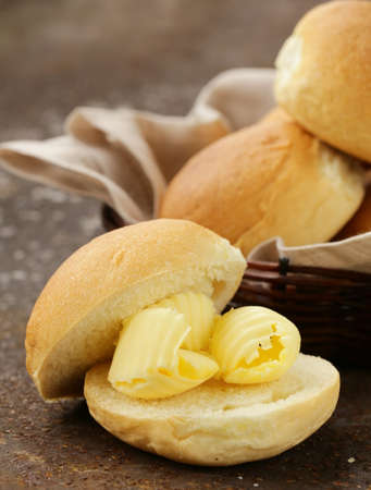 yellow dairy butter on a fresh bun bread for breakfast