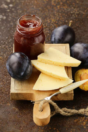 cheese board plate with plums jam and fresh fruitの写真素材