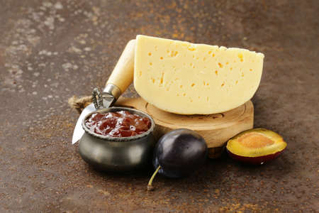 cheese board plate with plums jam and fresh fruitの写真素材