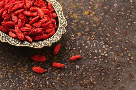 useful red goji berries on a old iron backgroundの写真素材