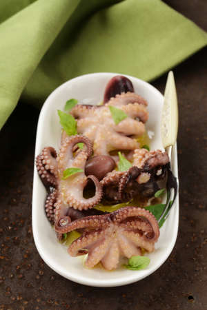 appetizer small marinated octopus (squid) with basil and olive oilの写真素材
