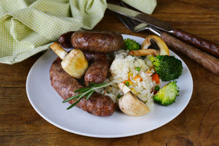 homemade meat sausages with vegetables garnish (broccoli and mushrooms)の写真素材
