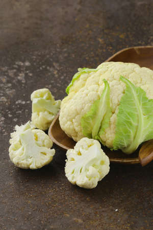 fresh organic white cauliflower on old iron tableの写真素材