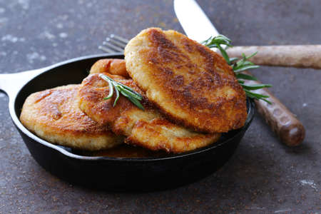 roasted meat burgers with rosemary in a pan