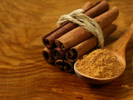 fragrant cinnamon sticks and ground spices on a wooden background