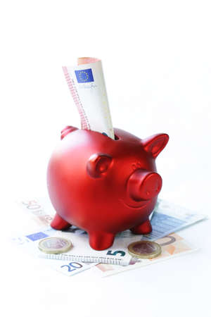 red piggy bank with euro banknotes and coinsの写真素材