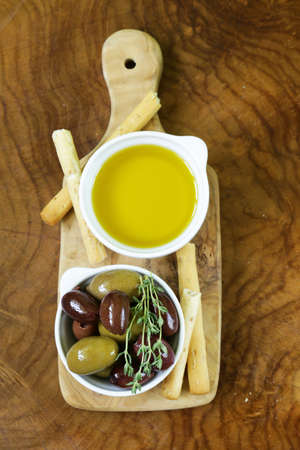 black and green olives in oil with herbsの写真素材