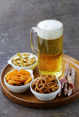 different salted snacks and a glass of fresh beer rustic still lifeの写真素材