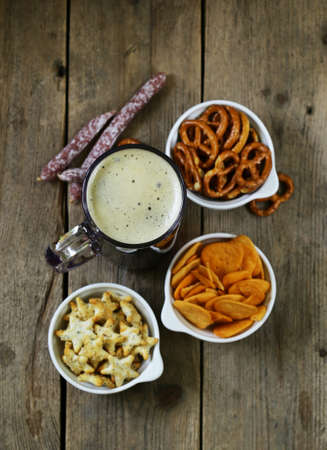 different salted snacks and a glass of fresh beer rustic still lifeの写真素材