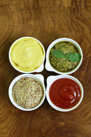 different types of sauces - ketchup, mustard, pesto