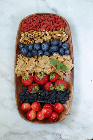 set of ingredients for a healthy food breakfast - muesli, fresh and dried fruit, nuts, goji berriesの写真素材
