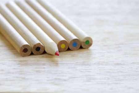 different colored wooden pencils on a wooden backgroundの写真素材