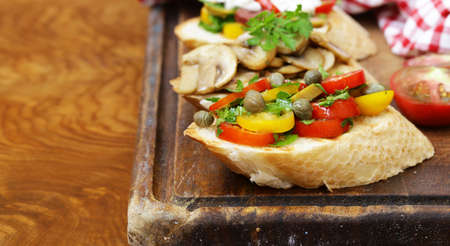 Italian appetizer bruschetta with tomatoes, olives, cheese and mushrooms