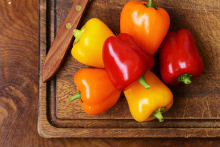 Fresh organic bell peppers on a wooden boardの写真素材