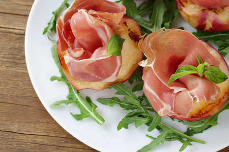 Italian appetizer grilled peaches with parma hamの写真素材