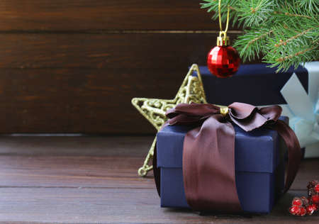gift boxes with festive ribbons and Christmas decorations on a wooden background