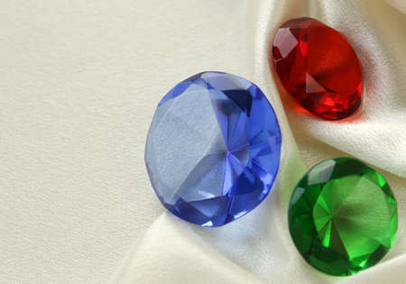 colored glass diamonds on a soft silk backgroundの写真素材
