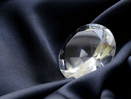 large glass diamond on soft black silk backgroundの写真素材