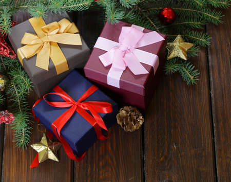 gift boxes with festive ribbons and Christmas decorations on a wooden background