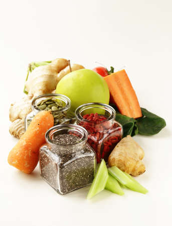 Super food - goji berries, chia seeds and pumpkin seeds with vegetables, fruits and herbsの写真素材