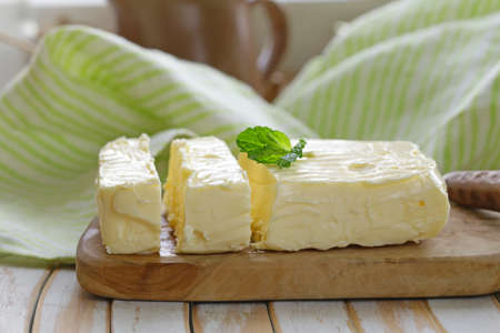 block of fresh organic butter on a wooden board