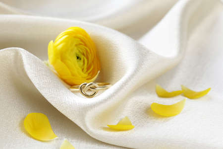 gold ring in the form of heart on a beige silk