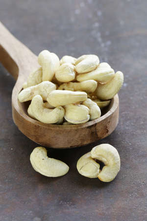 peeled cashew nuts in a wooden spoon