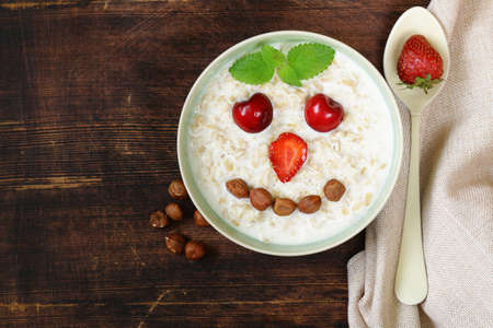 oatmeal porridge with milk and berries - healthy, funny breakfastの写真素材