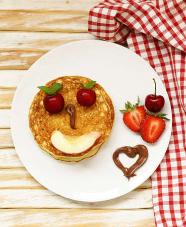 breakfast pancakes with berries (strawberry, cherry, banana), funny faceの写真素材