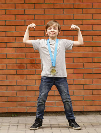 blond boy is happy gold medal - champion, winner