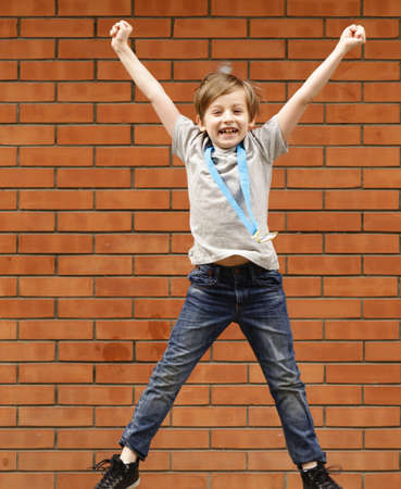 blond boy is happy gold medal - champion, winnerの写真素材