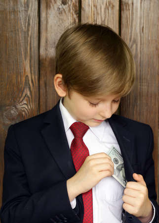 Boy in a suit with cash dollars - business conceptの写真素材