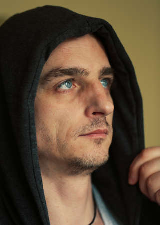 portrait of blonde man with blue eyes in the hood