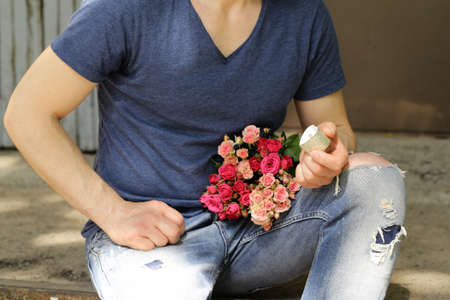 man with  bouquet of roses and diamond ring, ready to make a proposalの写真素材