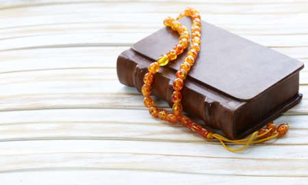 book in a vintage leather bound, and amber beads