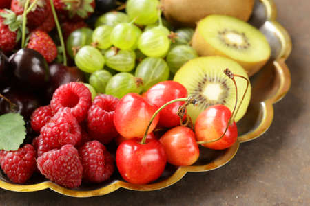 various fresh organic berries on a vintage silver plateの写真素材