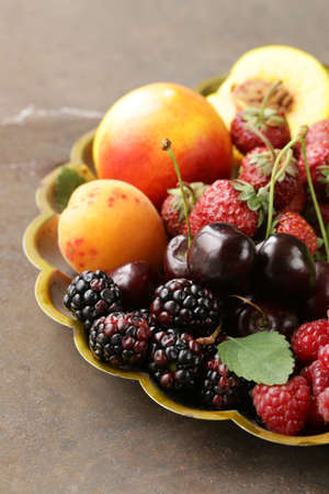various fresh organic berries on a vintage silver plate
