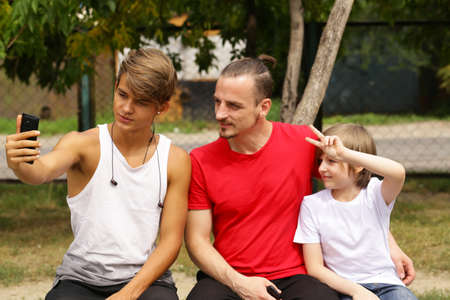 father and two sons posing for photo selfie
