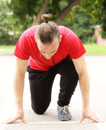 Young sports man at the start, ready to runの写真素材
