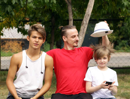 father and two sons sitting on a bench