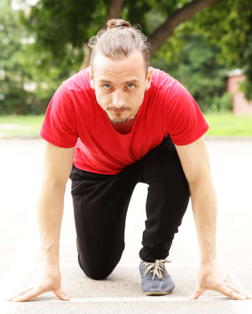 Young sports man at the start, ready to runの写真素材