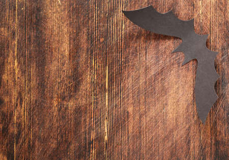 paper origami bats on a wooden background, decorations for the holiday Halloween