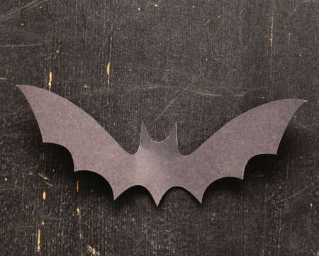 paper origami bats on a wooden background, decorations for the holiday Halloween