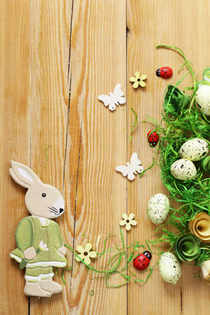 wooden background with Easter symbols, eggs, butterflies, flowers