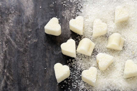 Granulated sugar and refined in the shape of heart on a wooden backgroundの写真素材