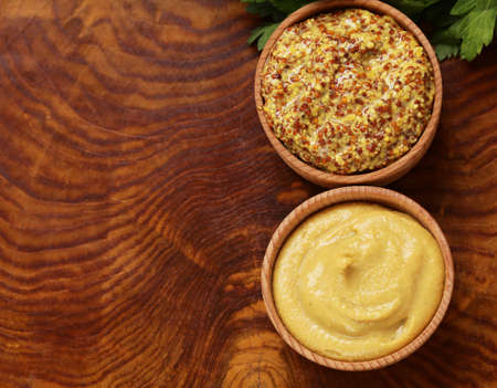 Natural mustard, seasoning and sauce on a wooden tableの写真素材