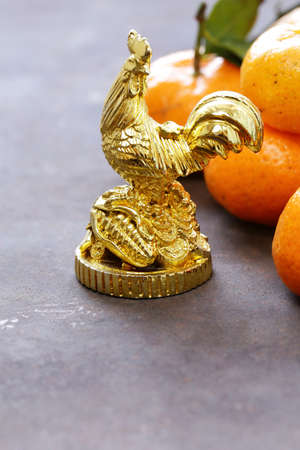 symbol of the new year, golden cock and tangerines, oriental calendarの写真素材