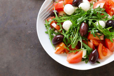 mozzarella salad with tomatoes and green arugulaの写真素材