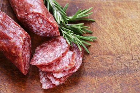salami sausage with rosemary on a wooden boardの写真素材